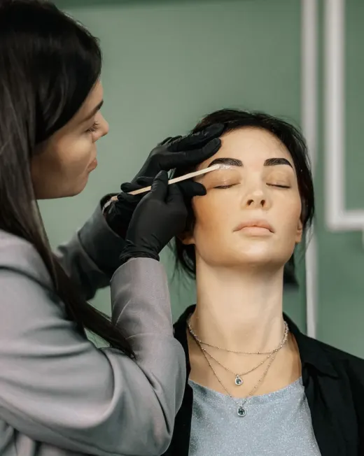 Eldivenli uzman, müşterisinin kaşını şekillendiriyor